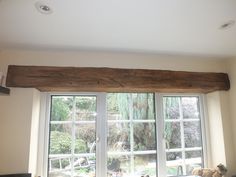 a living room with large windows and wooden beams