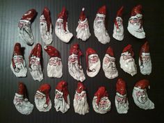 twelve santa claus figurines sitting on top of a black table next to each other