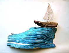 a small wooden boat on top of a wave covered rock with a tree on it