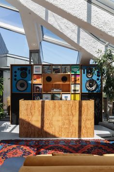 a room filled with lots of different types of speakers and bookshelves next to a rug