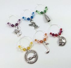 six wine charms with different colors and designs