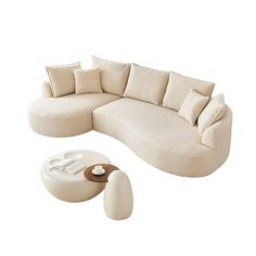 a large white couch sitting next to a table with some pillows on top of it