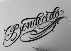 the word benedicto written in cursive writing on a white wall next to a pen