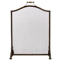 an old iron fireplace screen with white fabric