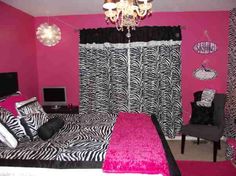 a bedroom decorated in zebra print with pink walls and black furniture, chandelier and curtains