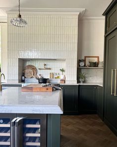 a large kitchen with an island in the middle and lots of cabinets on both sides