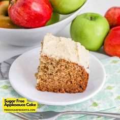 a piece of cake on a plate with apples in the background