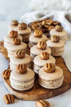 there are many macarons on the table with pecans around them and one has been cut in half