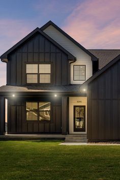 a house that is lit up at night with lights on the front and side windows