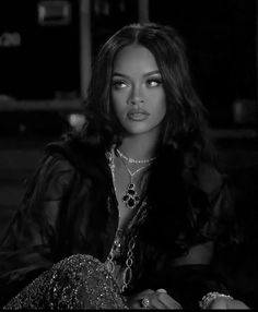 a black and white photo of a woman in a fur coat with jewelry on her neck