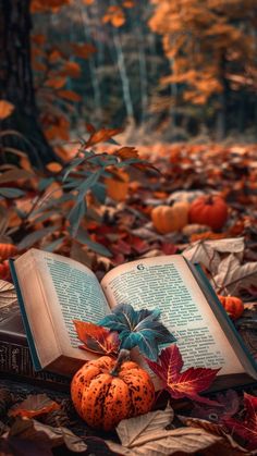 an open book sitting on top of a pile of leaves next to a bunch of pumpkins