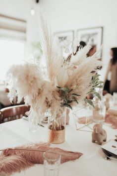 there is a vase with feathers on the table