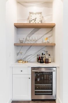 a kitchen with white cabinets and marble counter tops, including an oven in the corner