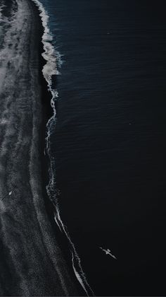 an aerial view of the ocean with waves coming in