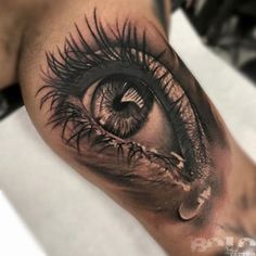 an eye is shown on the leg of a person with black and grey ink in it