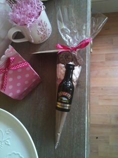 a bottle of beer sitting on top of a table next to a vase with flowers