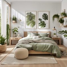 a bedroom with white walls, wooden floors and green plants on the wall above the bed