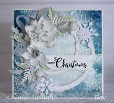 a christmas card with white flowers and snowflakes on the front, blue background