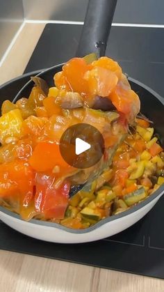 a pan filled with vegetables on top of a stove