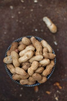 a bowl filled with peanuts on top of a table