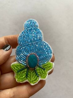 "Entirely beaded brooch on felt of a retro whimsical conch shell. Inspired by the great Schlumberger who made phenomenal one of a kind jewelry. Measures 3.5\" x 2\"" Shell Brooch, Unique Beaded Brooches For Crafting, Decorated Conch Shell, Unique Handmade Turquoise Brooches, Unique Handmade Turquoise Brooch, Handmade Turquoise Brooches For Collectible, Ocean-inspired Beaded Shell, Unique Beaded Shell-shaped Necklace, Vintage Shell-shaped Jewelry For Beach