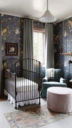 a bedroom with floral wallpaper and a metal crib in the corner next to a window