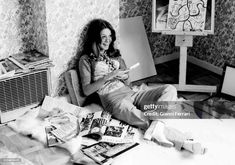 a woman sitting on the floor in front of paintings