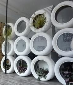 a bunch of tires stacked on top of each other with plants growing out of them