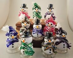 a group of snowmen sitting next to each other on top of a wooden table