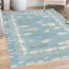 a blue area rug with clouds and airplanes on it in a living room next to a chair