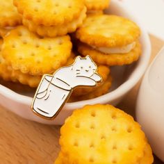 a white bowl filled with crackers and a cat pin