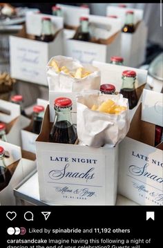 bottles of wine and snacks are on display at a wedding or other function in boxes