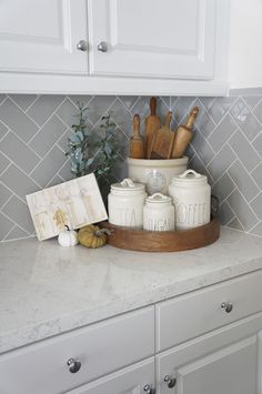 kitchen utensils and wooden spoons are sitting on the counter