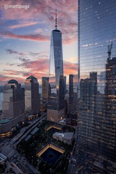 an aerial view of skyscrapers in the city at sunset or dawn, with one world trade center visible