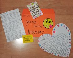 some paper hearts are sitting on a table next to an open envelope with a note attached