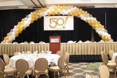 a banquet hall with tables and chairs set up for a 50th birthday party in front of a sign that reads 50