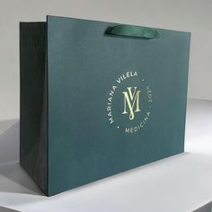 a green shopping bag sitting on top of a white table