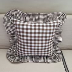 a brown and white checkered pillow sitting on top of a couch