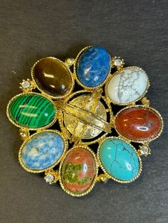 1980s Multi-stone Cabochon and gold tone brooch. Exc. Cond. Gold Cabochon Brooches For Jewelry Making, Multicolor Cabochon Brooches As Gift, Multicolor Cabochon Brooches For Collectors, Unique Multicolor Cabochon Brooches, Ceremonial Gold Cabochon Brooches, Antique Gold Brooches With Cabochon, Vintage Gold Cabochon Brooch, Vintage Multi-stone Gold Brooches, Vintage Gold Multi-stone Brooches