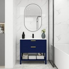 a bathroom with marble walls and blue vanity, white bathtub and mirror on the wall