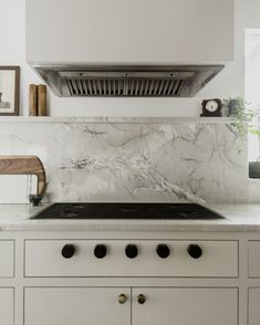 a stove top oven sitting inside of a kitchen next to a wall mounted range hood