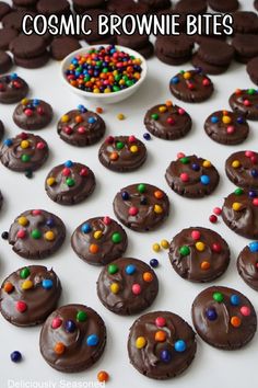 Mini brownie bites laid out on a white board covered with chocolate frosting and colorful candies on top. Mini Brownie Bites, After Dinner Dessert, Brownie Bites Recipe, Homemade Brownie, Cosmic Brownies, Bite Size Snacks, Chocolate Melting Wafers, Bite Size Cookies, Dessert Plating