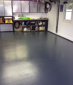 an empty garage with black floors and lots of storage