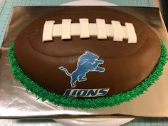 a cake shaped like a football with the detroit lions on it