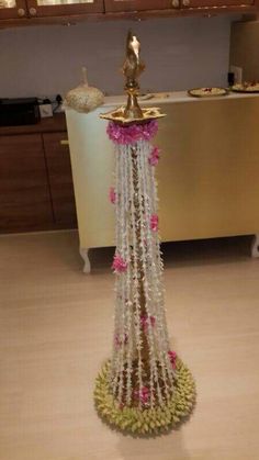 a gold statue with white and pink flowers on it in front of a kitchen counter