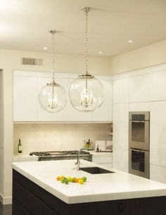 a kitchen with two lights hanging from the ceiling