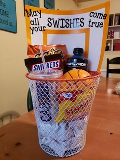 a basket filled with sports items sitting on top of a wooden table next to a sign