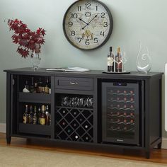 a clock mounted to the side of a wall next to a wine cabinet with bottles and glasses