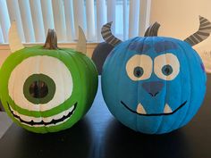 two paper pumpkins decorated to look like monsters