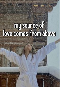 a woman with her arms outstretched in the air while she is wearing a white robe